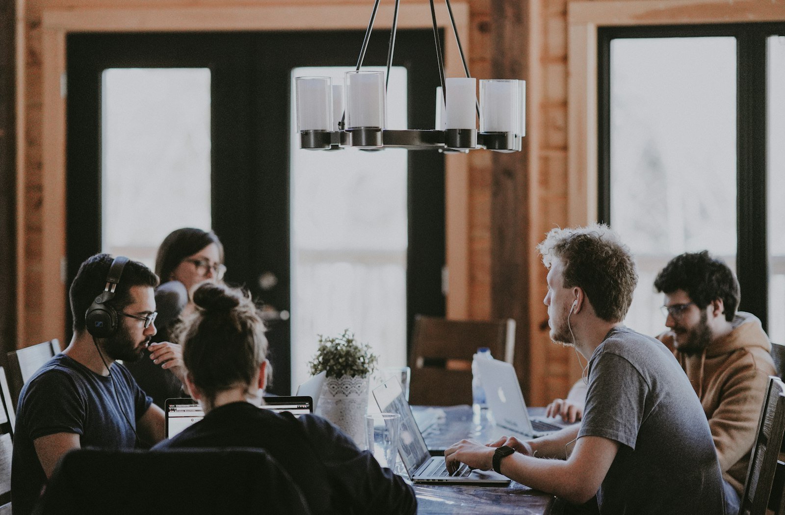 A group of professionals collaborating around a table with laptops
